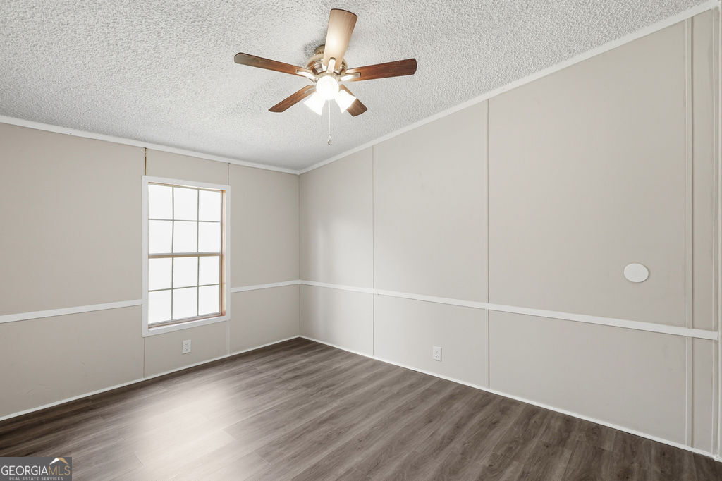 196 Barn Rd Circle Jesup, GA 31545 - Photo 15 of 31 an empty room with wooden floor fan and windows