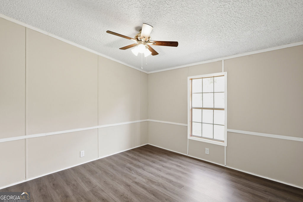 196 Barn Rd Circle Jesup, GA 31545 - Photo 16 of 31 an empty room with wooden floor fan and windows