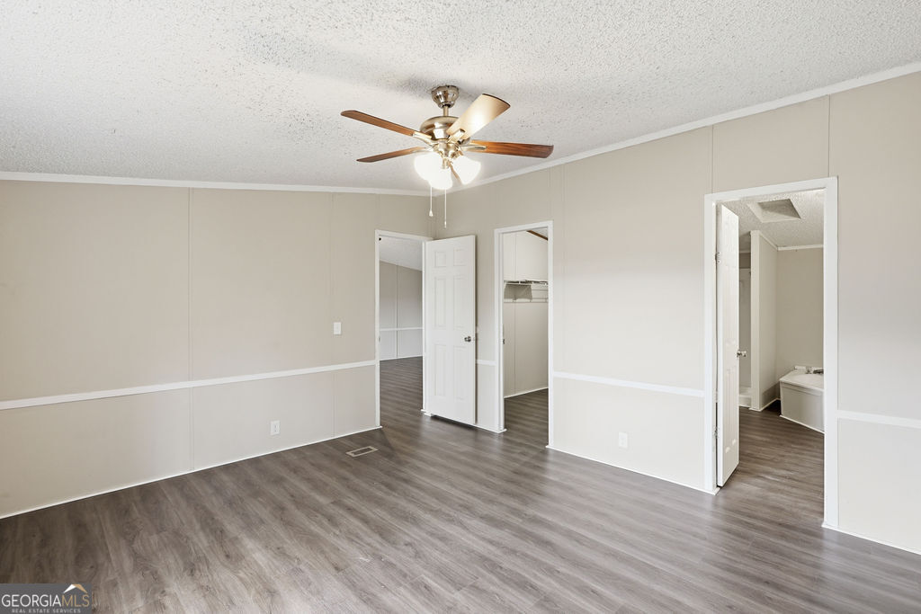 196 Barn Rd Circle Jesup, GA 31545 - Photo 17 of 31 a view of an empty room with wooden floor and a ceiling fan