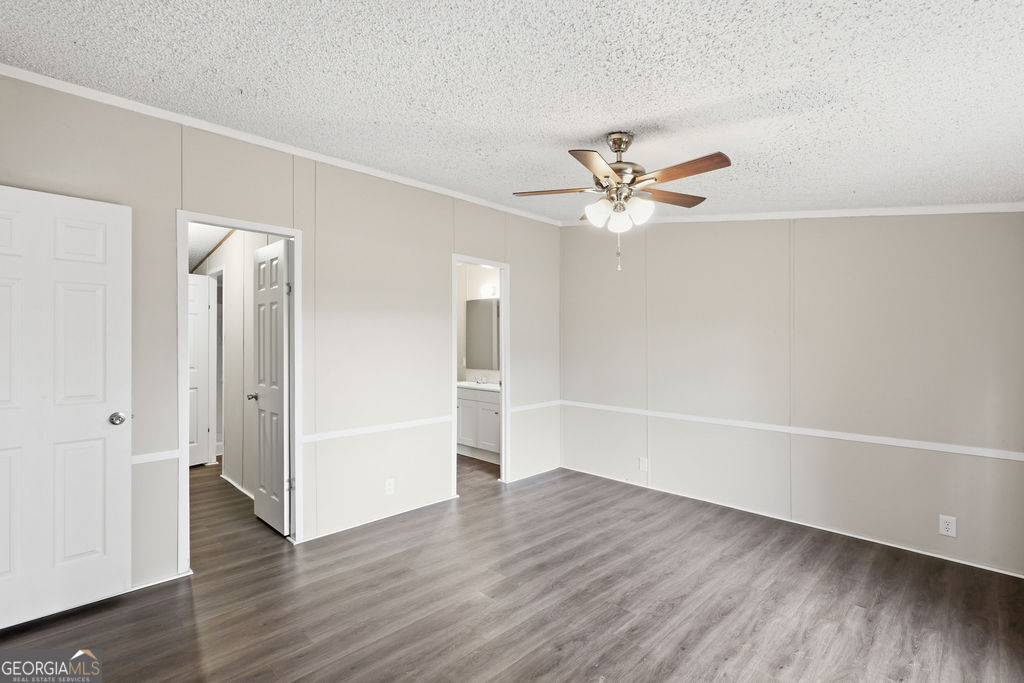 196 Barn Rd Circle Jesup, GA 31545 - Photo 18 of 31 an empty room with wooden floor and a ceiling fan