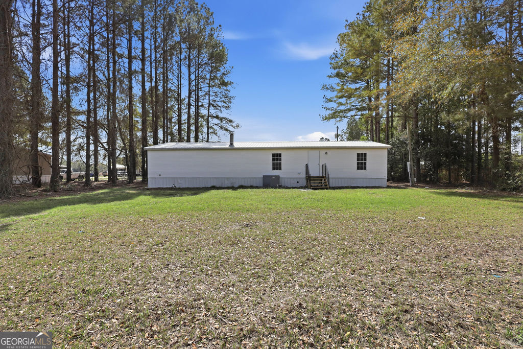 196 Barn Rd Circle Jesup, GA 31545 - Photo 29 of 31 a view of house with backyard and trees