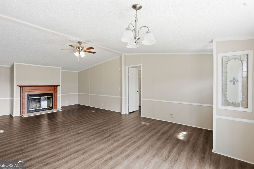 196 Barn Rd Circle Jesup, GA 31545 - Photo 5 of 31 an empty room with wooden floor fireplace and windows