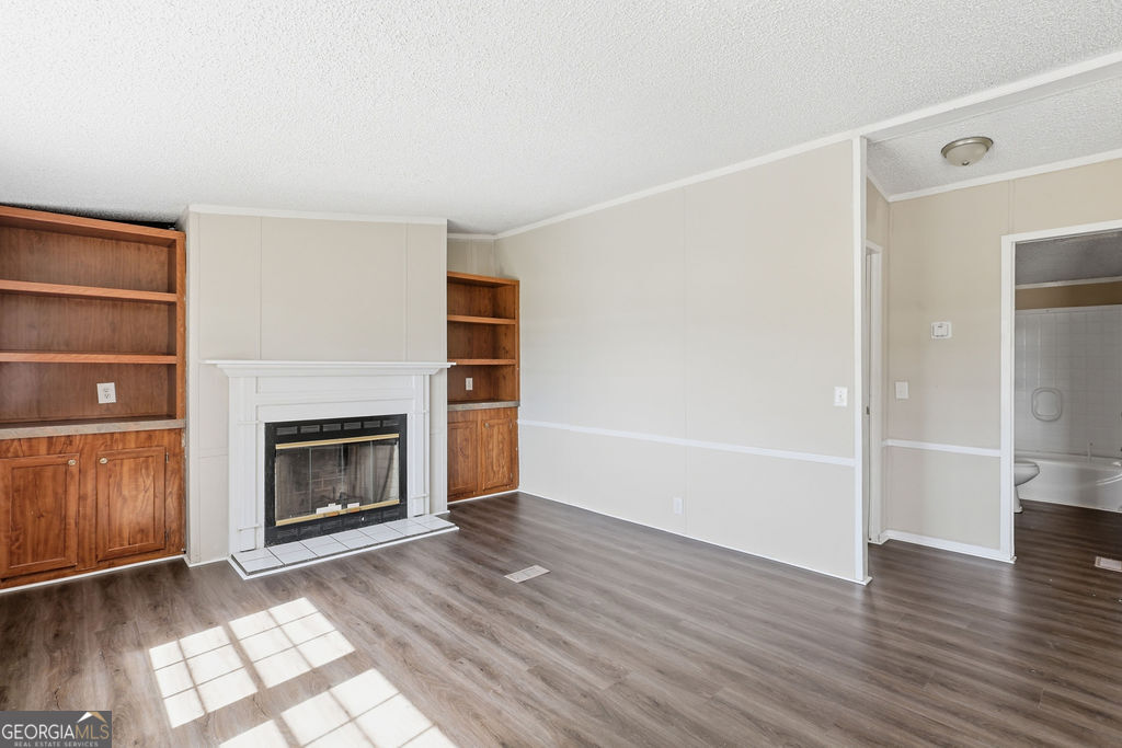 196 Barn Rd Circle Jesup, GA 31545 - Photo 10 of 31 a view of an empty room with wooden floor fire place and windows