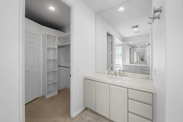 a view of a pathway with a bench under palm trees