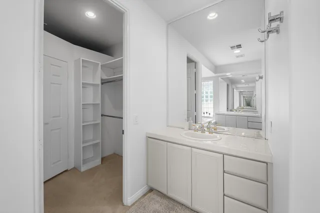 a view of a pathway with a bench under palm trees