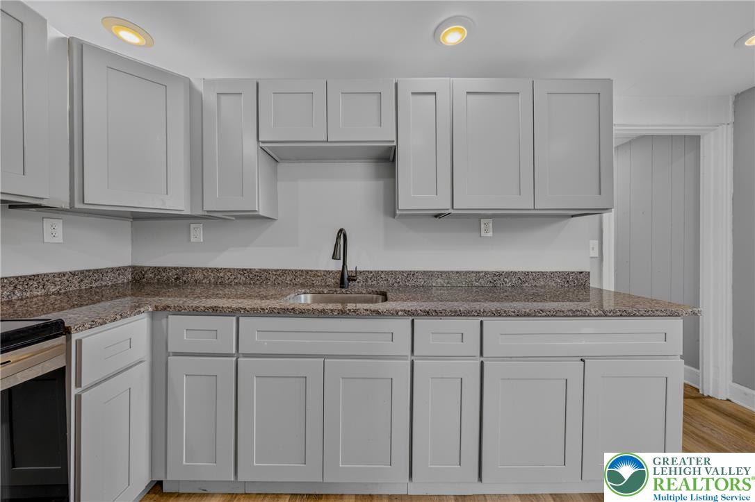 313 Main Street Slatington, PA 18080 - Photo 53 of 73 A well-appointed kitchen features ample gray cabinetry and elegant granite countertops, creating a pristine culinary space.