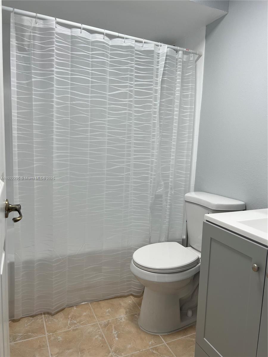 27510 Southwest 138th Path Homestead, FL 33032 - Photo 12 of 35 a bathroom with a toilet and a shower curtain