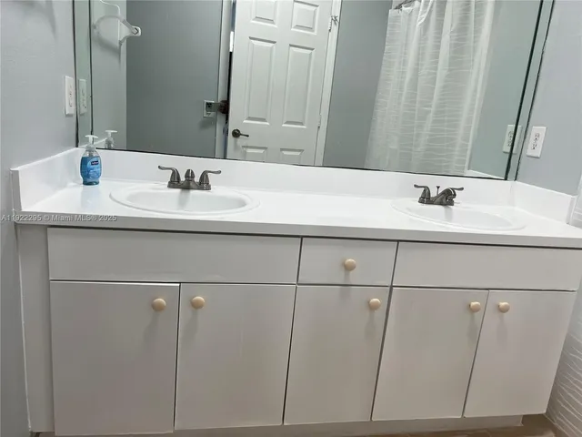 a view of a house with a small yard and large trees