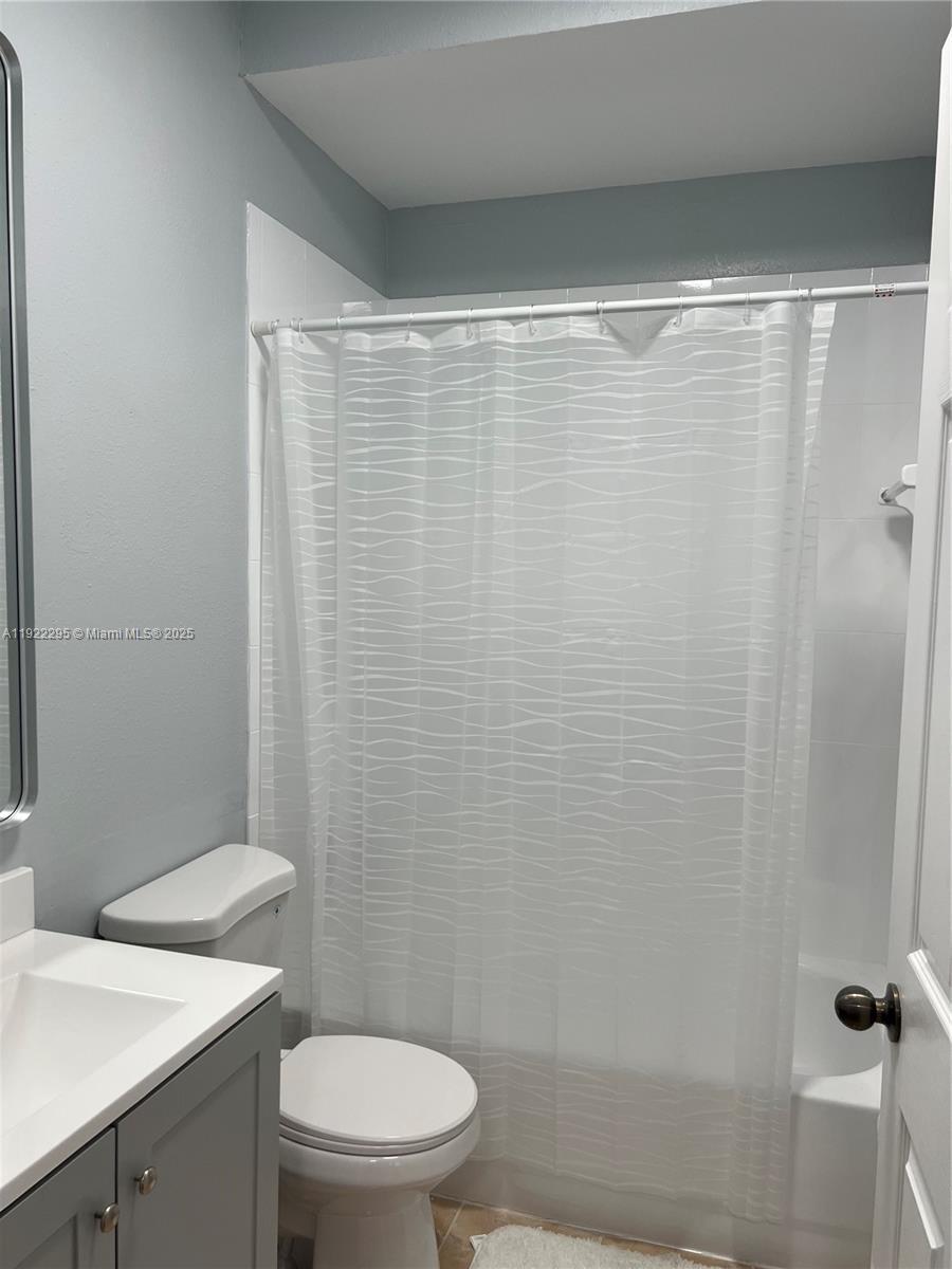 27510 Southwest 138th Path Homestead, FL 33032 - Photo 24 of 35 a bathroom with a toilet and a shower curtain