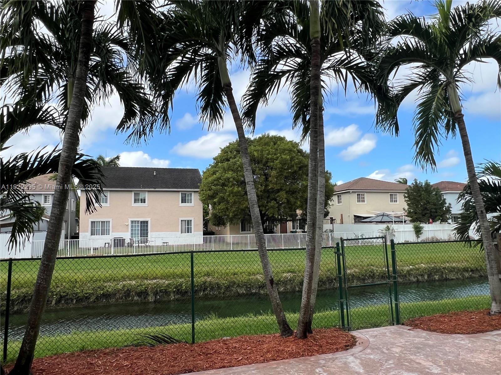 27510 Southwest 138th Path Homestead, FL 33032 - Photo 31 of 35 a view of a house with a yard and palm trees
