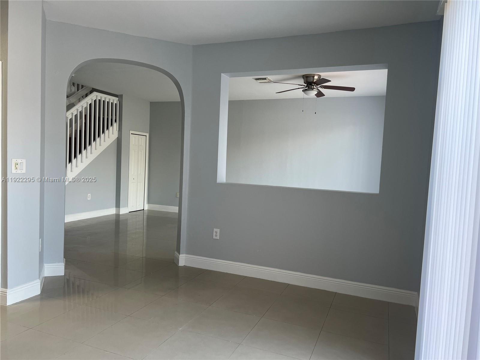 27510 Southwest 138th Path Homestead, FL 33032 - Photo 7 of 35 an empty room with a chandelier fan and wooden floor