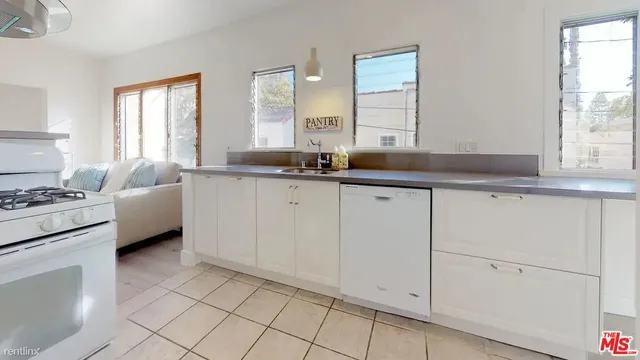 a kitchen with granite countertop white cabinets and white appliances