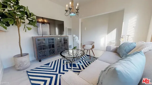 a living room with furniture a chandelier and a window