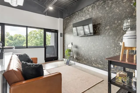 a living room with furniture and a floor to ceiling window