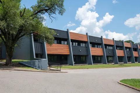 a brick building with a view of multi story residential apartment building