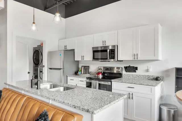 a kitchen with stainless steel appliances granite countertop a sink stove and refrigerator