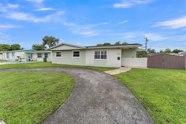 a front view of a house with a garden and yard