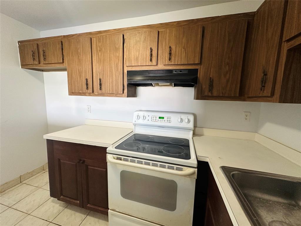 4174 Inverrary Drive, Unit 805 Lauderhill, FL 33319 - Photo 13 of 26 a kitchen with wooden cabinets and a stove top oven