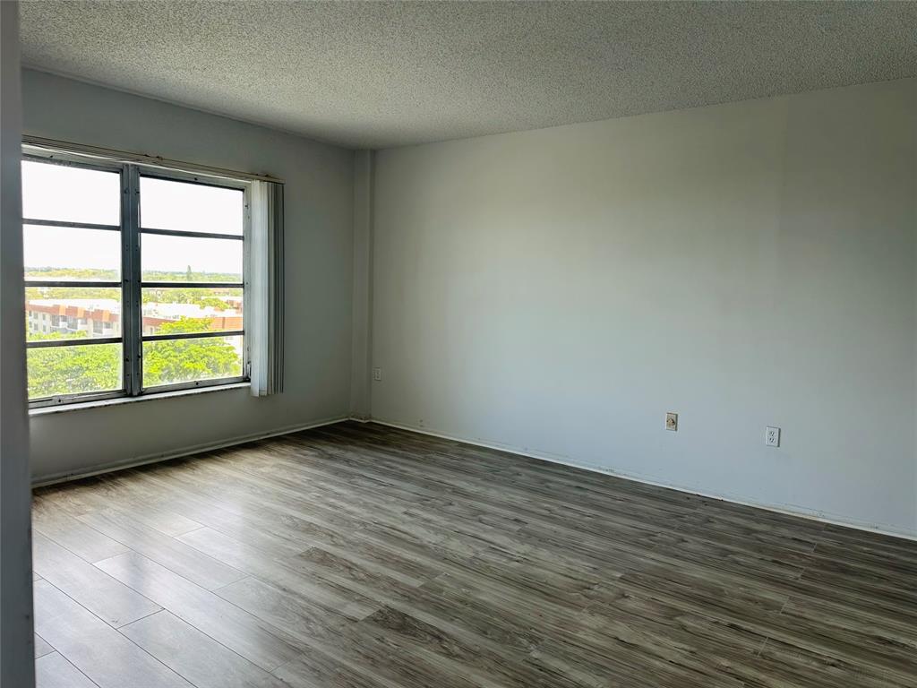 4174 Inverrary Drive, Unit 805 Lauderhill, FL 33319 - Photo 18 of 26 an empty room with wooden floor and windows