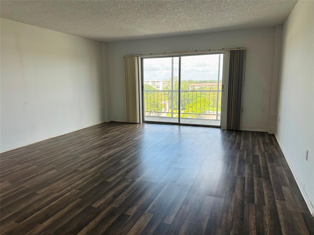 4174 Inverrary Drive, Unit 805 Lauderhill, FL 33319 - Photo 5 of 26 a view of an empty room with wooden floor and a window