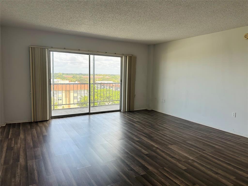 4174 Inverrary Drive, Unit 805 Lauderhill, FL 33319 - Photo 7 of 26 a view of an empty room with wooden floor and a window