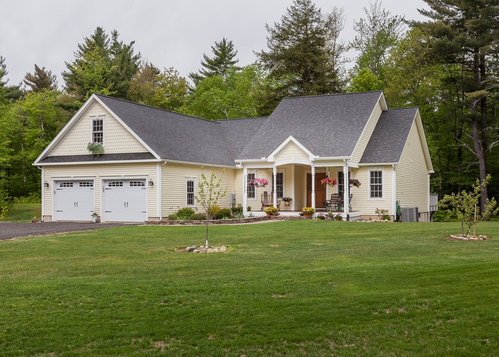 75 Schoolhouse Road Tolland, MA 01034 - Photo 3 of 30 a front view of a house with a garden and trees