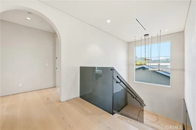 a spacious bedroom with a bed and glass floor to ceiling window