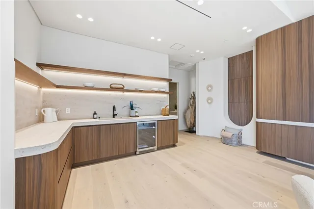 a large kitchen with a refrigerator a sink dishwasher and white cabinets next to a window