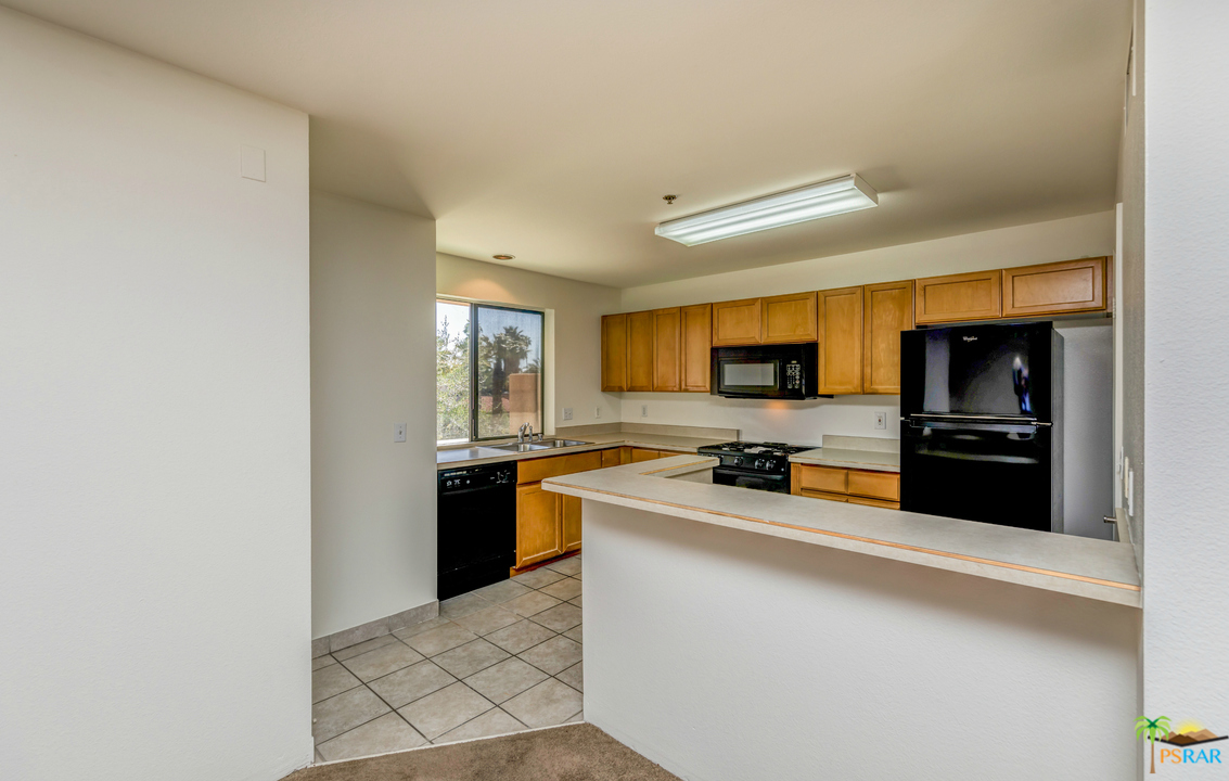 100 East Stevens Road, Unit 513 Palm Springs, CA 92262 - Photo 11 of 39 a large kitchen with stainless steel appliances a sink and a refrigerator