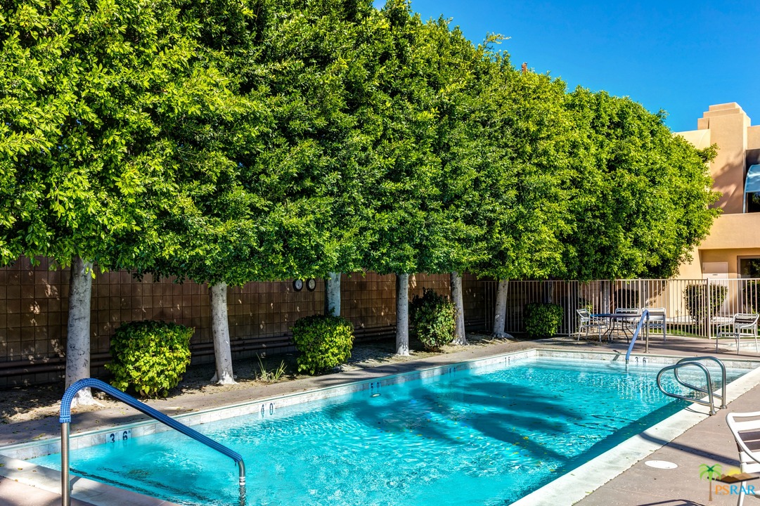 100 East Stevens Road, Unit 513 Palm Springs, CA 92262 - Photo 2 of 39 a backyard of a house with table and chairs plants and large trees