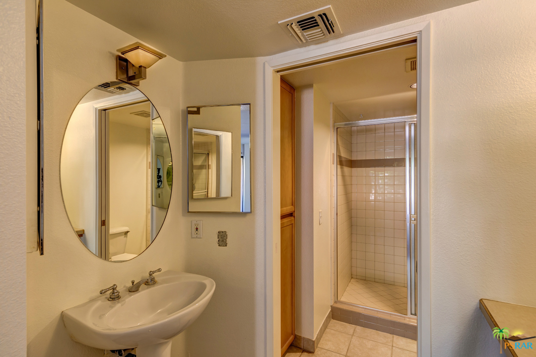 100 East Stevens Road, Unit 513 Palm Springs, CA 92262 - Photo 21 of 39 a bathroom with a sink a mirror and a shower