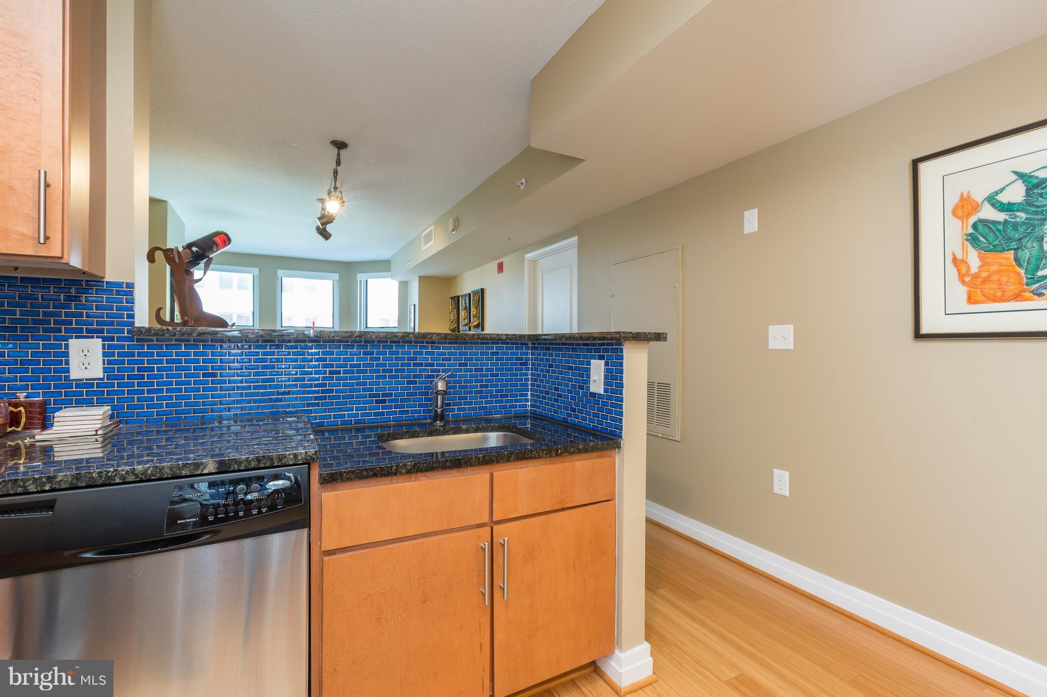915 E Street Northwest, Unit 613 Washington, DC 20004 - Photo 19 of 30 a kitchen with granite countertop a sink and a stove with wooden floor