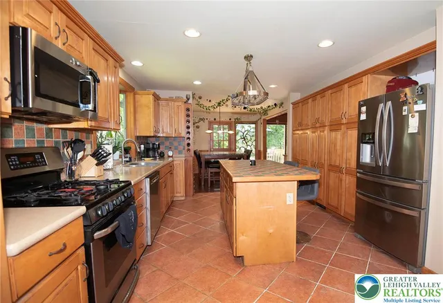 a kitchen with stainless steel appliances granite countertop a stove a sink a refrigerator and a microwave