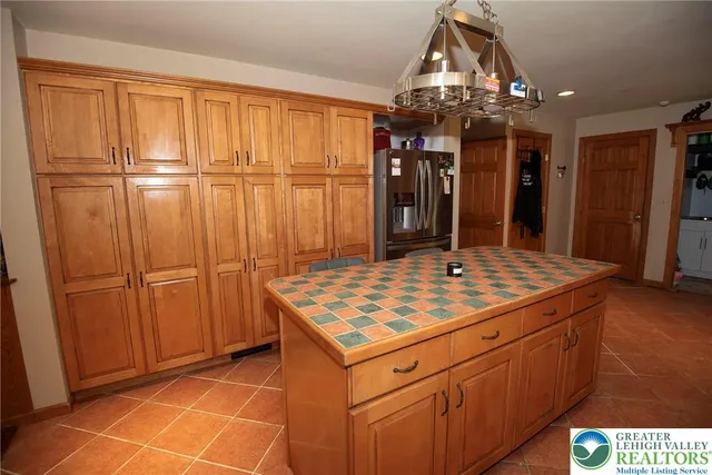 a kitchen that has a kitchen island wooden cabinets and stainless steel appliances