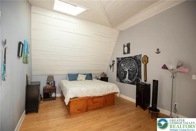 a bedroom with bed and wooden floor