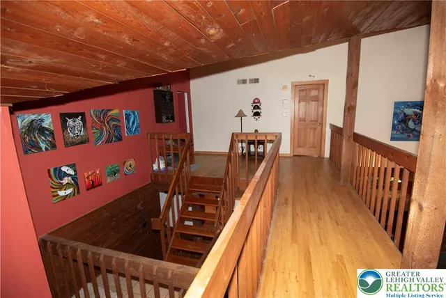 a view of a hallway with wooden floor and stairs