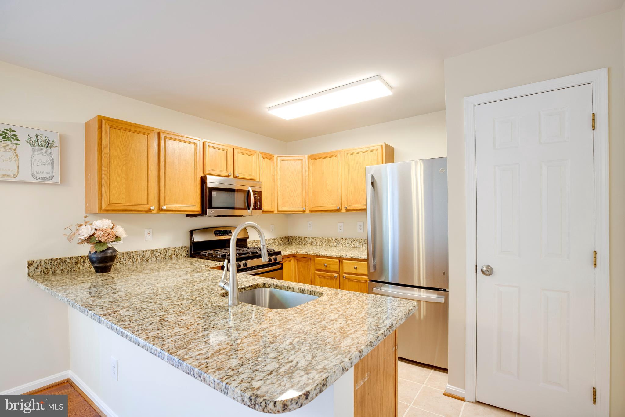 14113 Asher View Centreville, VA 20121 - Photo 15 of 47 a kitchen with stainless steel appliances granite countertop a sink refrigerator and microwave