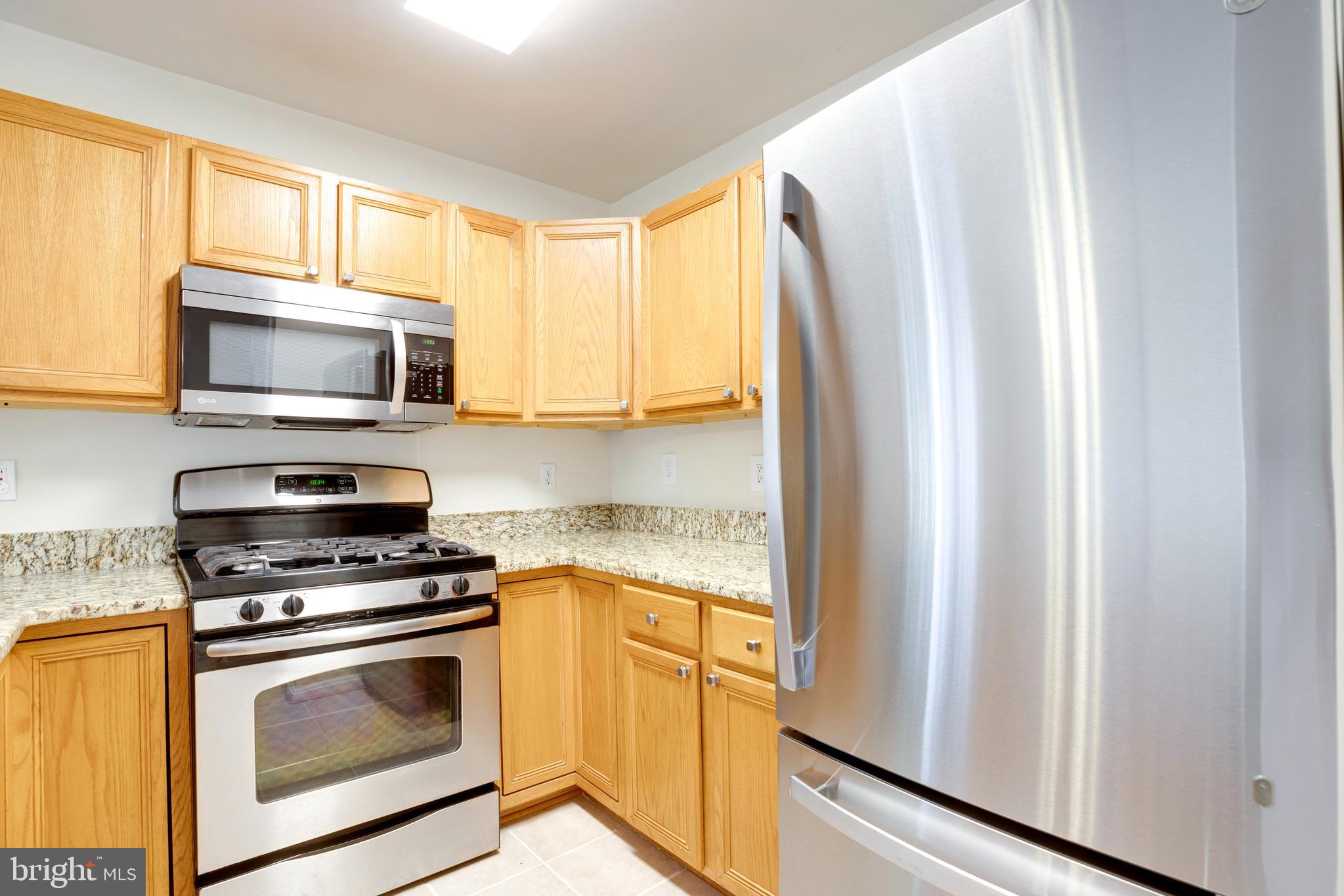 14113 Asher View Centreville, VA 20121 - Photo 16 of 47 a kitchen with stainless steel appliances a stove a microwave and a window