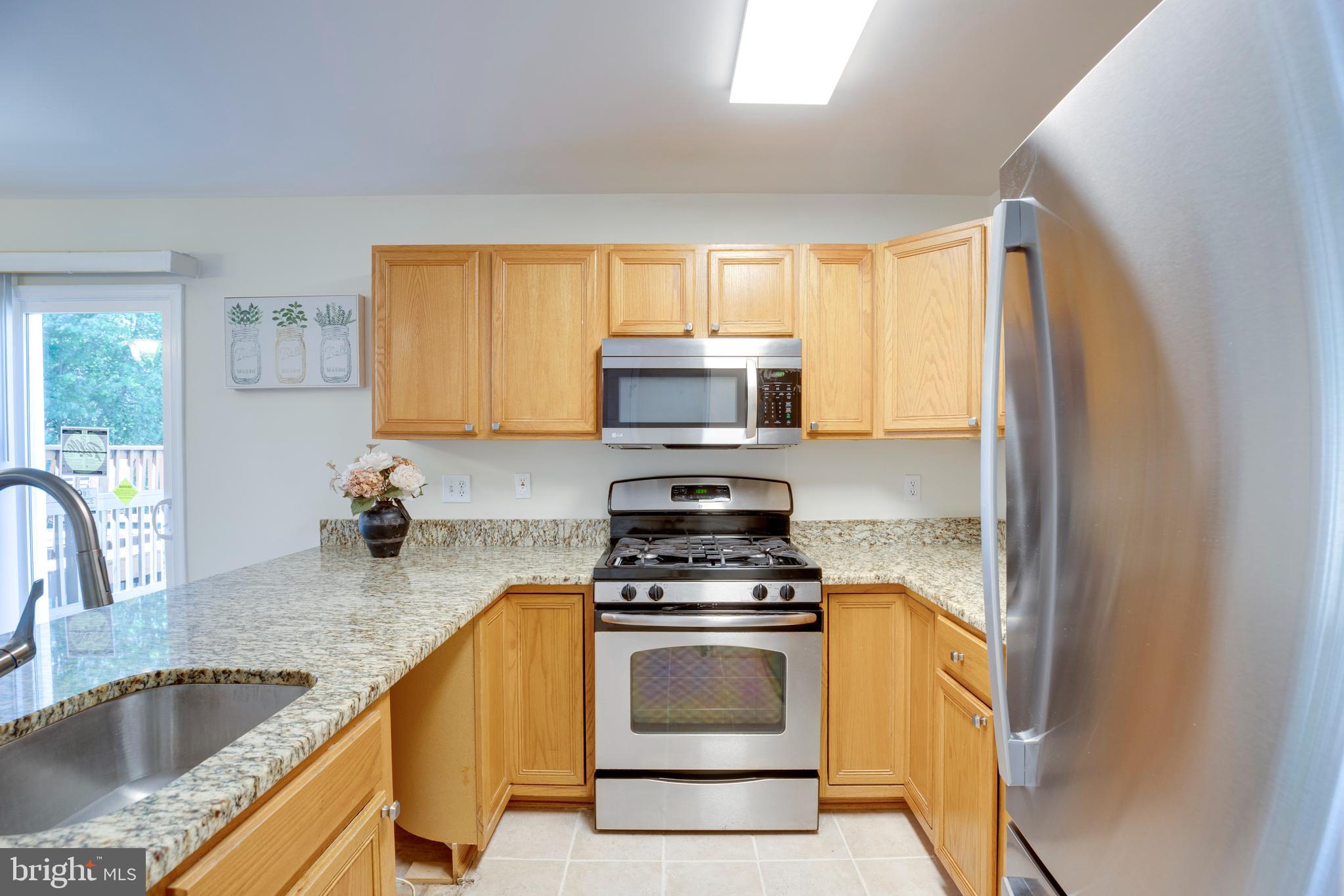 14113 Asher View Centreville, VA 20121 - Photo 17 of 47 a kitchen with granite countertop a sink cabinets and stainless steel appliances