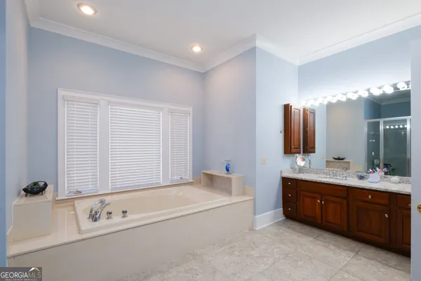 a bedroom with a bed a flat screen tv and a window