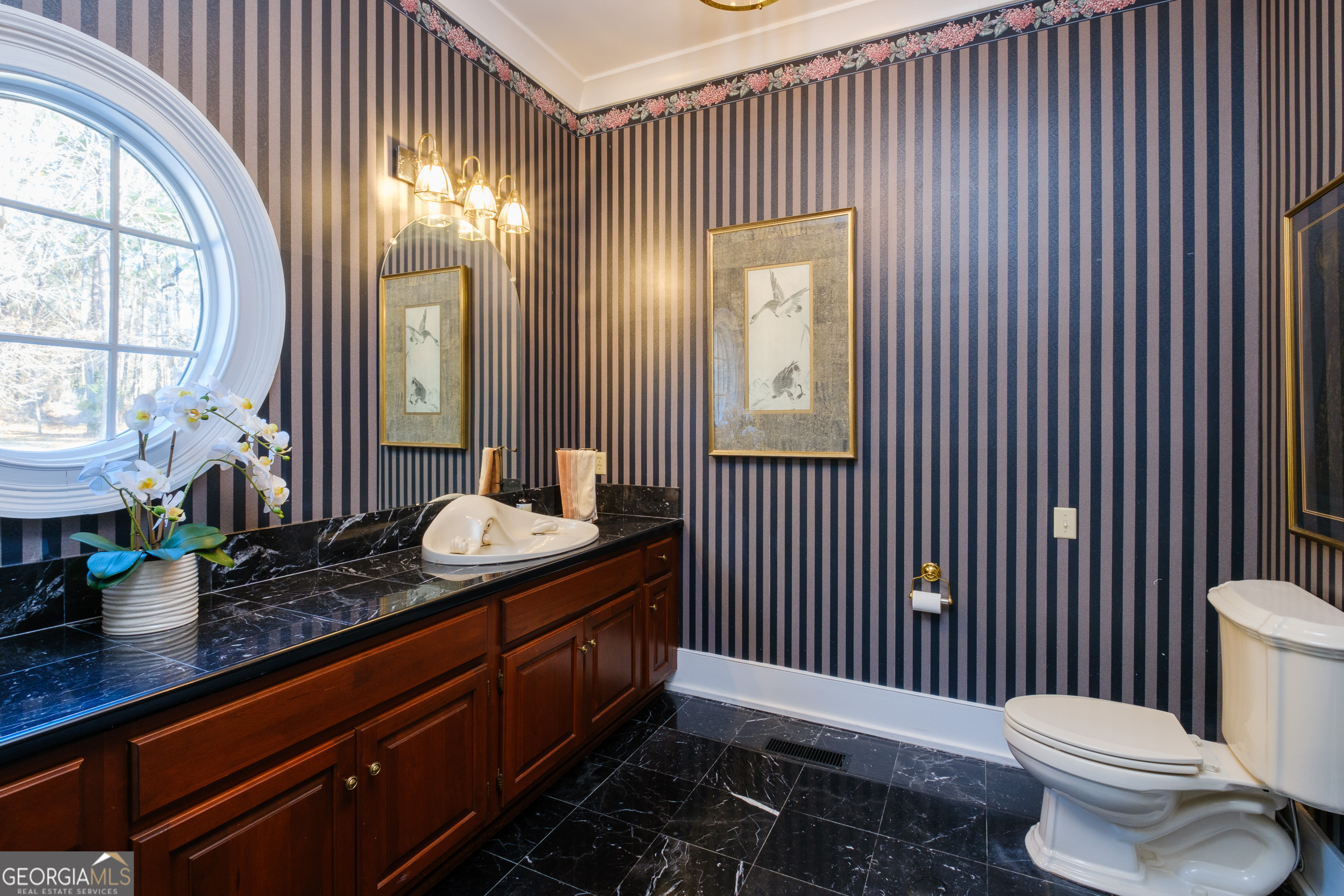 1900 Country Club Road Statesboro, GA 30458 - Photo 6 of 80 a bathroom with a granite countertop sink a toilet a mirror and a window