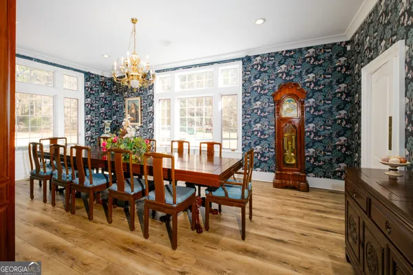 a view of a dining room with furniture a chandelier and wooden floor
