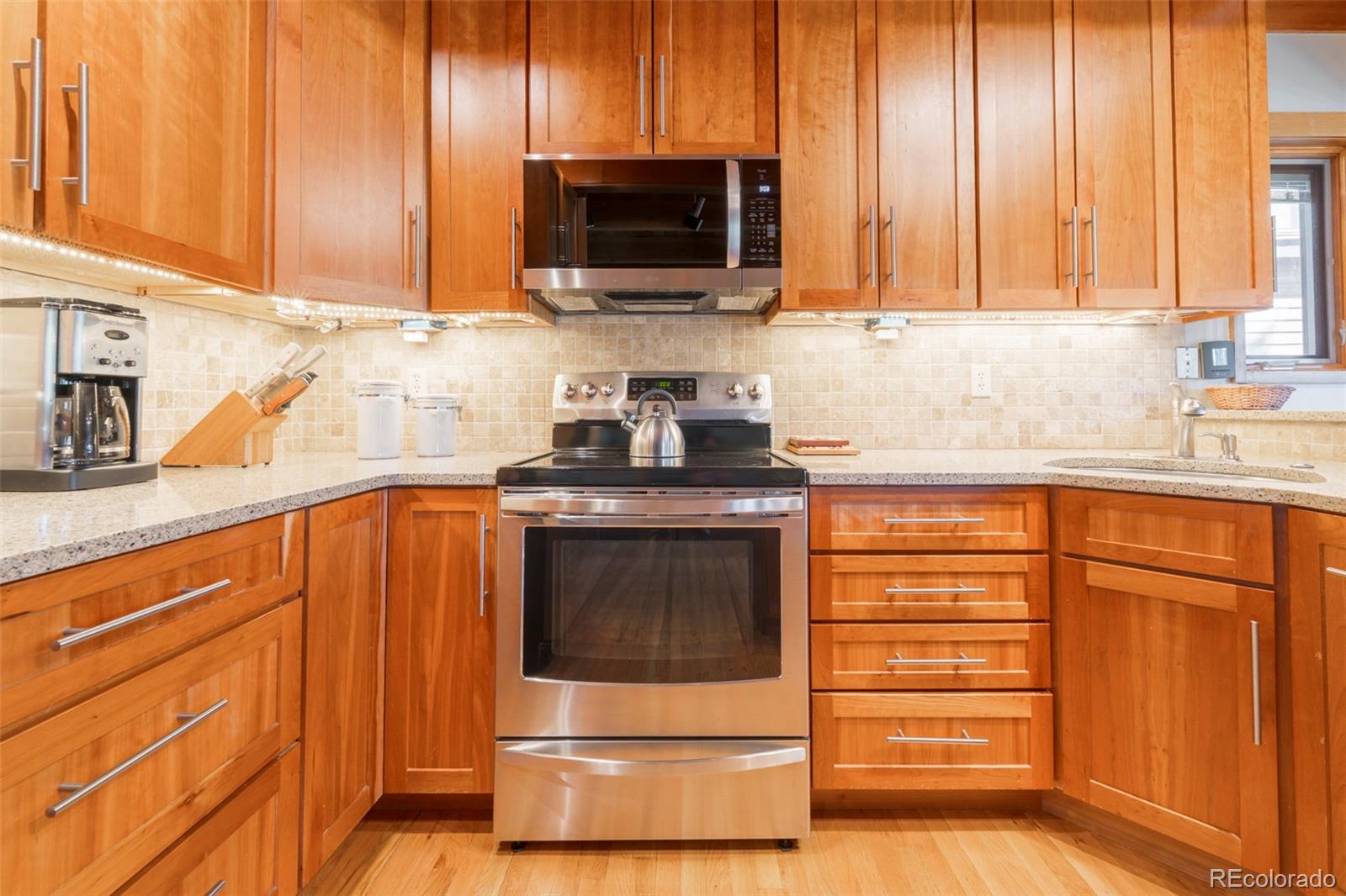350 Tennis Club Road, Unit 1311 Dillon, CO 80435 - Photo 10 of 45 a kitchen with granite countertop wooden cabinets and stainless steel appliances