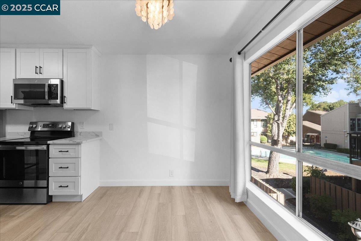 8975 Alcosta Boulevard, Unit 116 San Ramon, CA 94583 - Photo 6 of 31 a kitchen with stainless steel appliances a stove top oven a sink and a window
