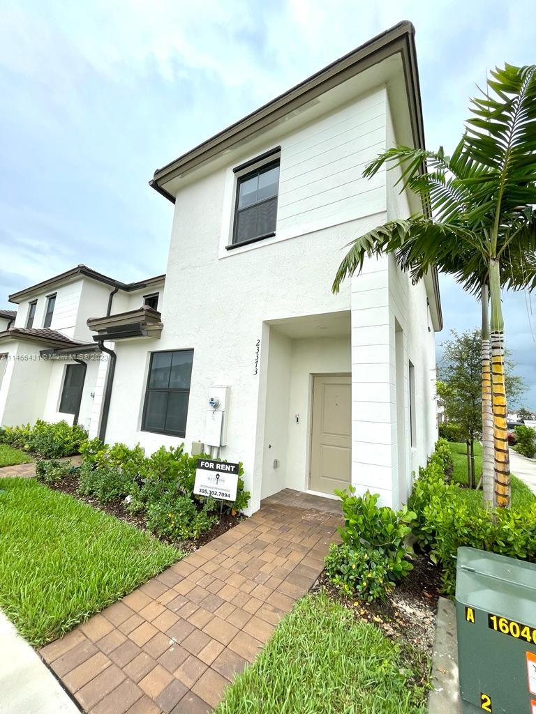 23373 Southwest 129th Path, Unit 23373 Miami, FL 33186 - Photo 1 of 20 a front view of a house with a yard and potted plants
