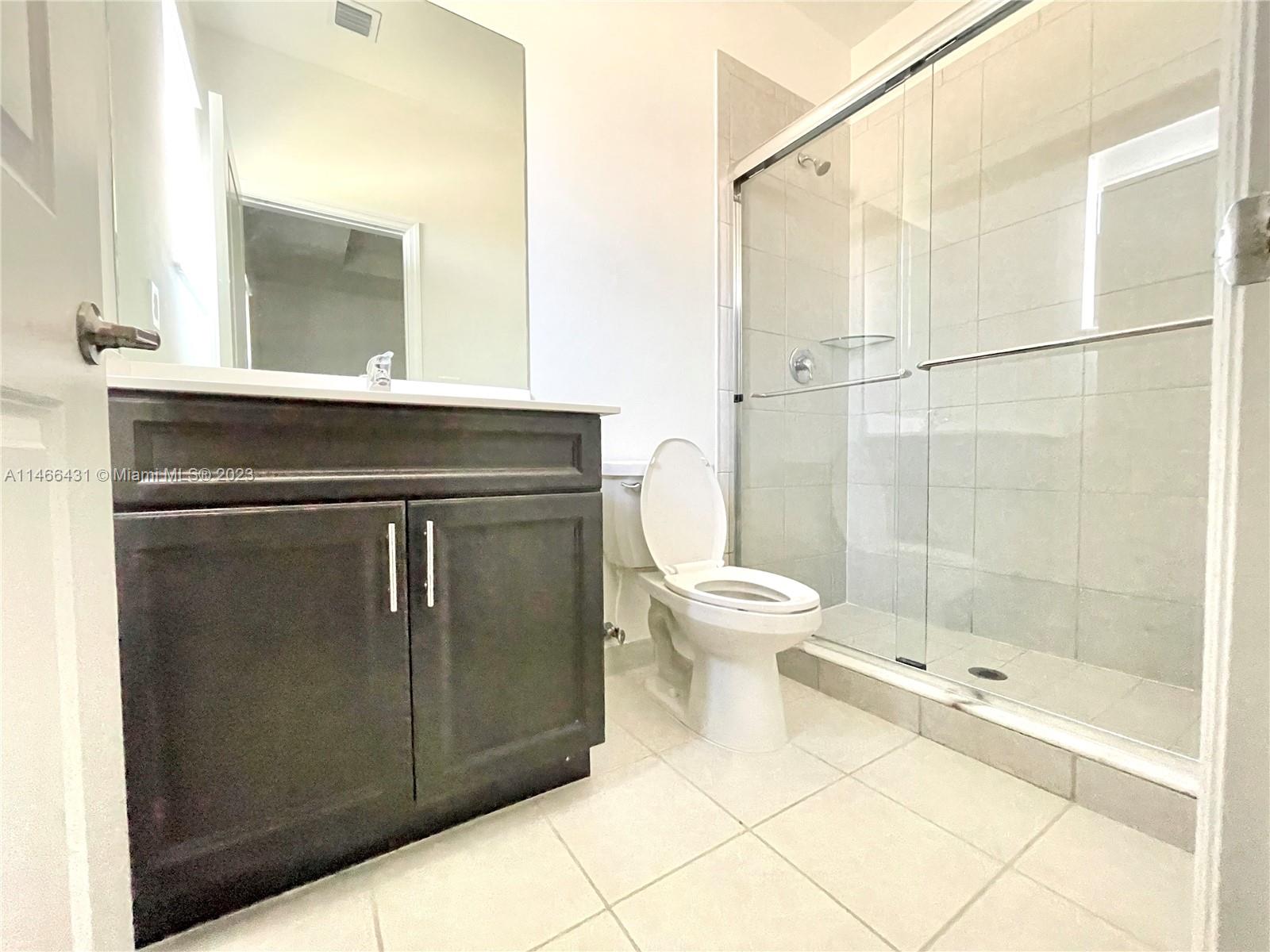 23373 Southwest 129th Path, Unit 23373 Miami, FL 33186 - Photo 14 of 20 a bathroom with a toilet a sink and shower