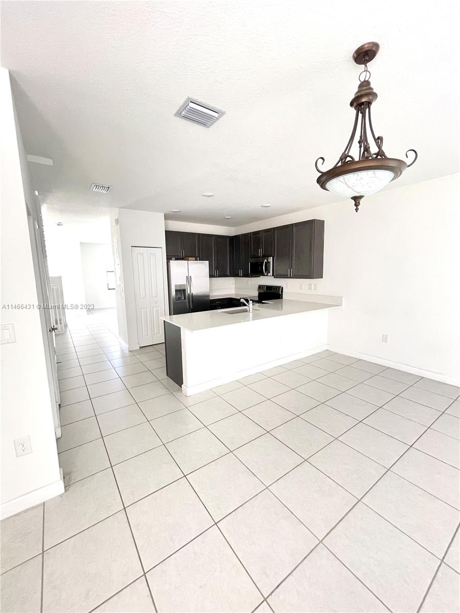23373 Southwest 129th Path, Unit 23373 Miami, FL 33186 - Photo 7 of 20 a kitchen with stainless steel appliances a sink stove and white cabinets