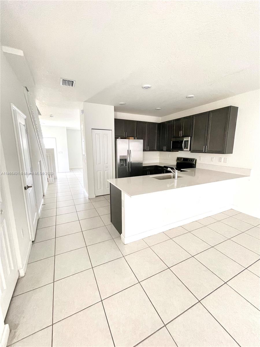 23373 Southwest 129th Path, Unit 23373 Miami, FL 33186 - Photo 8 of 20 a kitchen with stainless steel appliances a refrigerator sink and cabinets
