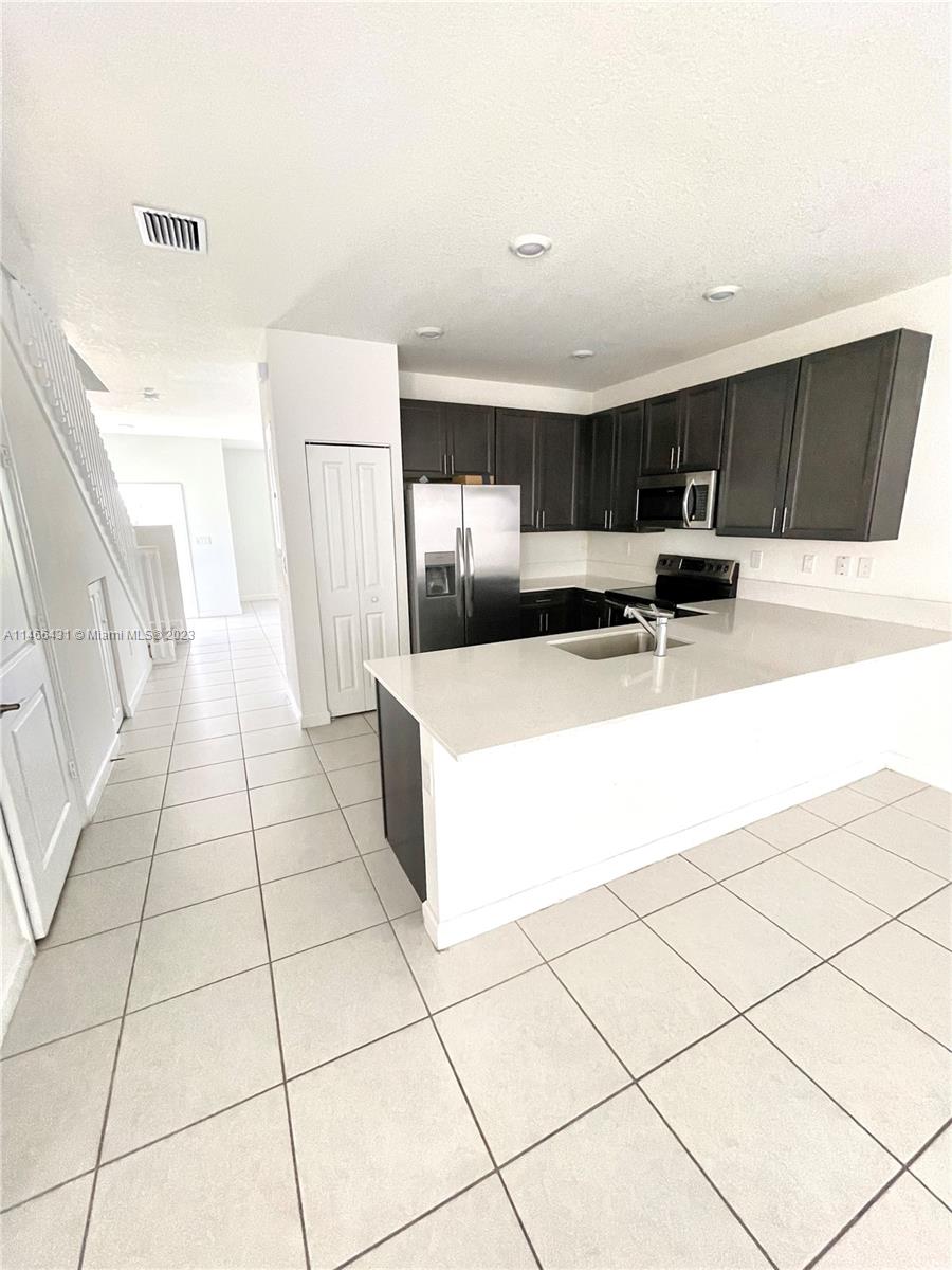 23373 Southwest 129th Path, Unit 23373 Miami, FL 33186 - Photo 9 of 20 a large white kitchen with a sink and cabinets