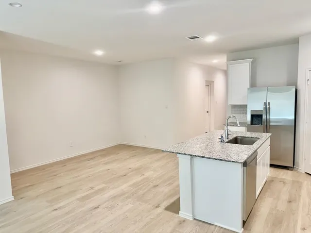a kitchen with a sink cabinets and wooden floor